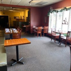 Interior of restaurant with red walls, checkered carpet, tables and chairs