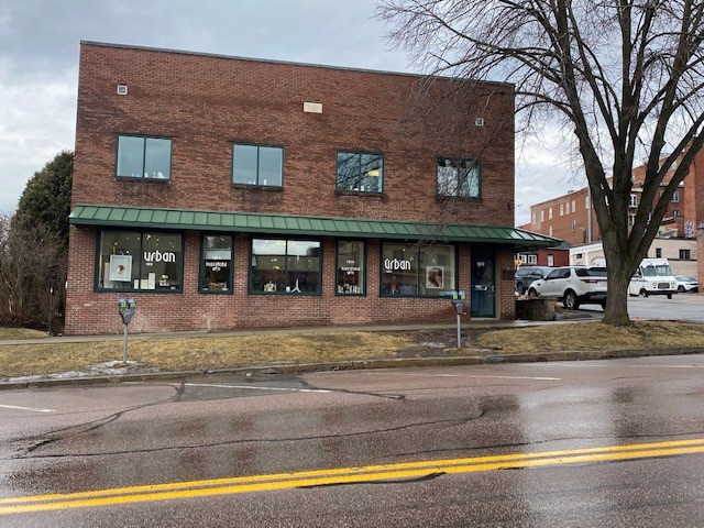 Street view of former Urban Salon space, 2-story brick building with green awning