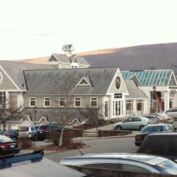Exterior building and parking lot view of shopping plaza at Manchester, VT retail outlets